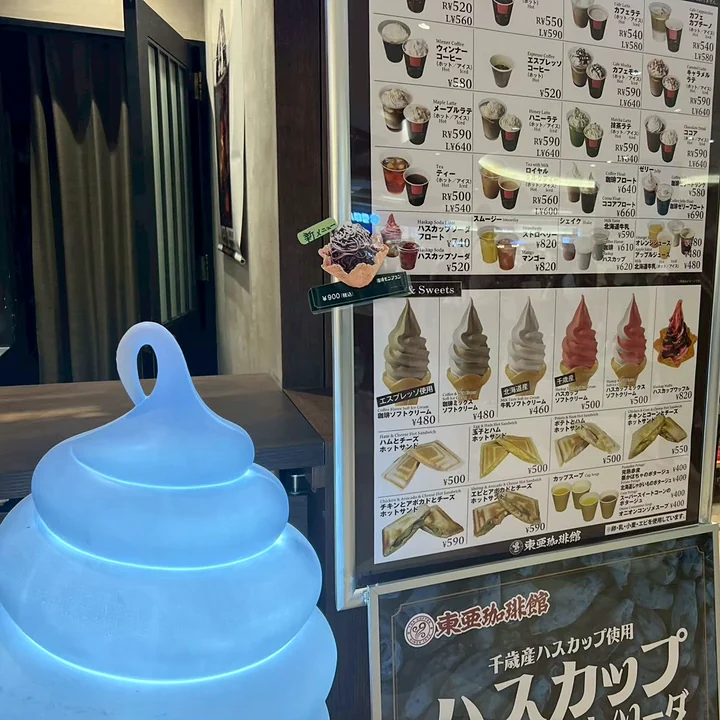 東亜珈琲館 新千歳空港店の店頭のメニュースタンドとソフトクリーム形のライト