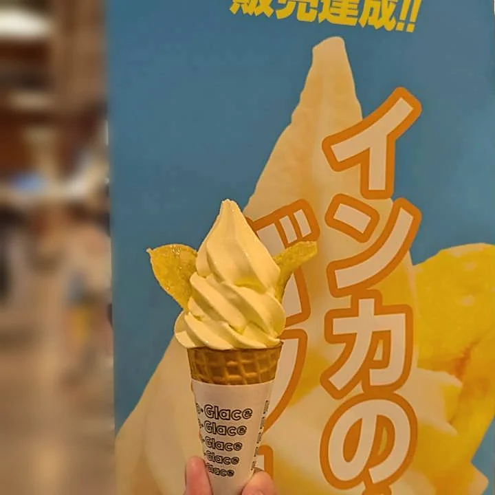 インカのめざめバターソフトのバナーの前で持ったソフトクリーム